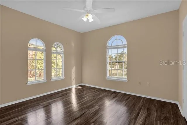 a view of empty room with wooden floor and window