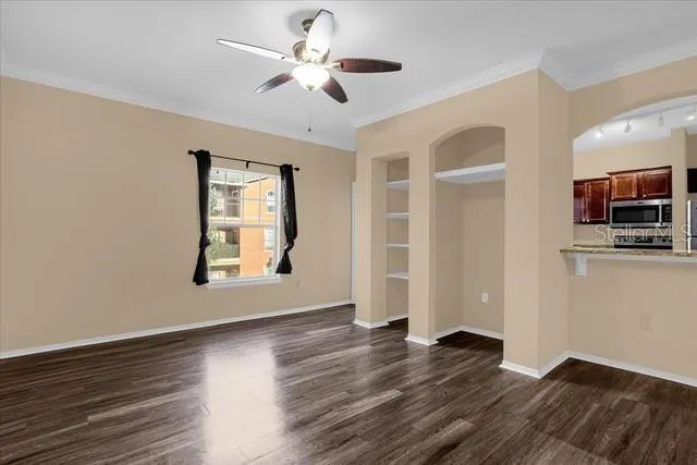 a view of an empty room with a window and wooden floor