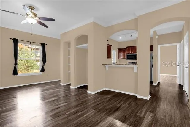 a view of a kitchen with wooden floor and a ceiling fan