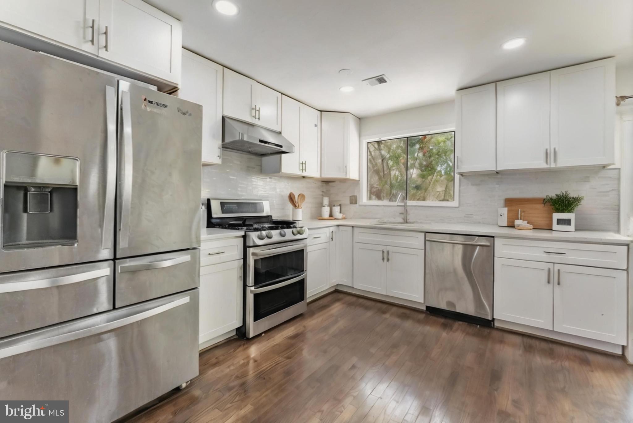 2412 Southgate Square Reston, VA 20191 - Photo 5 of 23 a kitchen with white cabinets stainless steel appliances and window