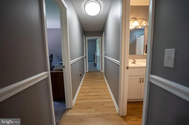 a view of a hallway with wooden floor and staircase