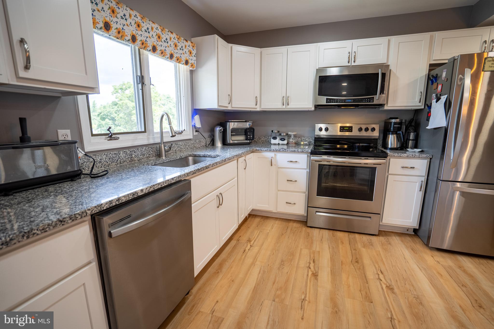 474 Potter Road Hedgesville, WV 25427 - Photo 7 of 40 a kitchen with stainless steel appliances a stove a sink a microwave and cabinets