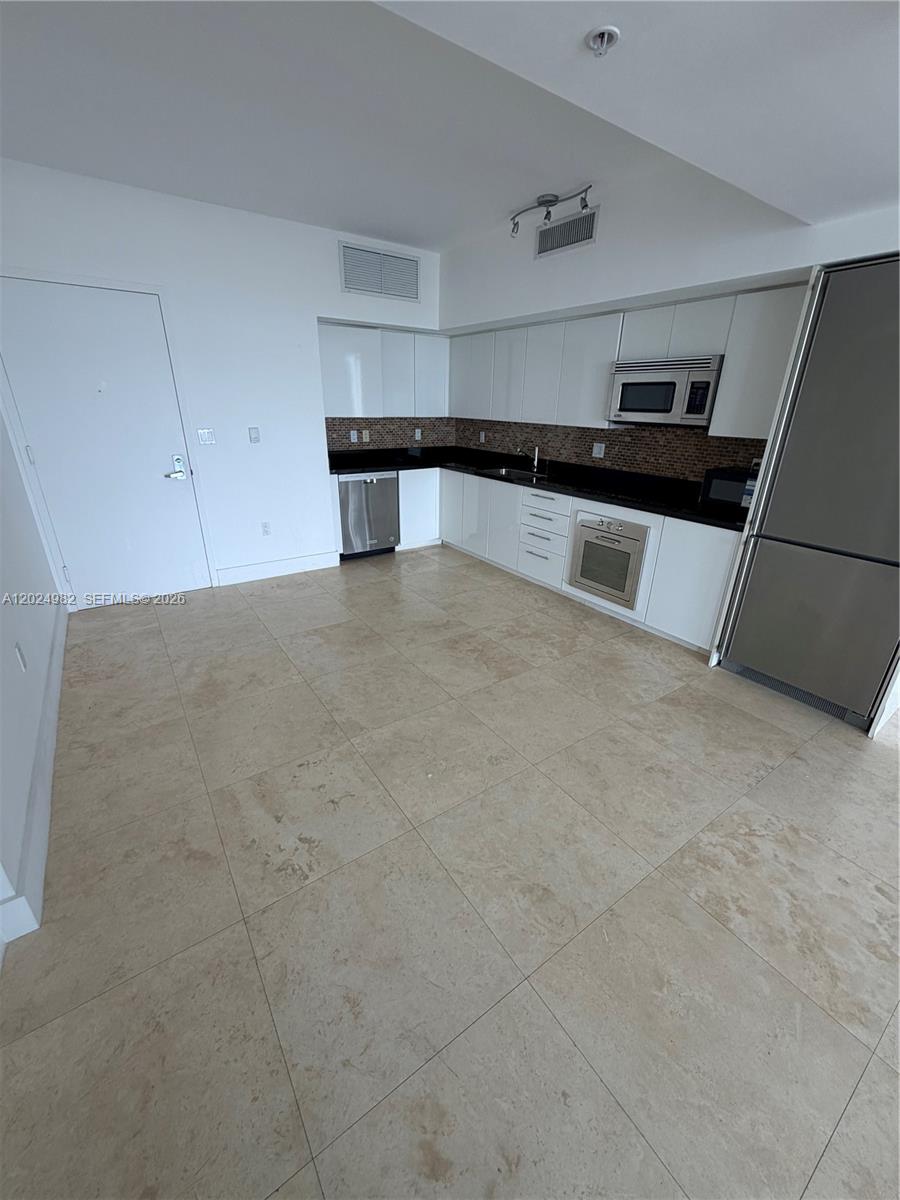 92 Southwest 3rd Street, Unit 3909 Miami, FL 33130 - Photo 2 of 13 a kitchen with granite countertop a refrigerator and a sink