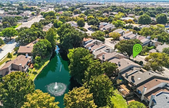 an aerial view of residential houses with outdoor space and trees