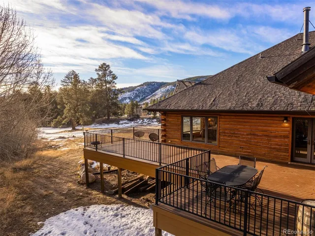 a view of a roof deck with table and chairs with wooden floor and fence