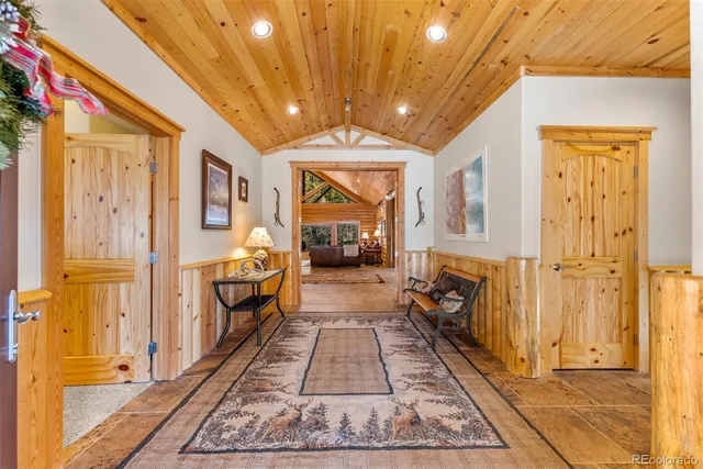 a hallway with white doors wooden floor and a chandelier