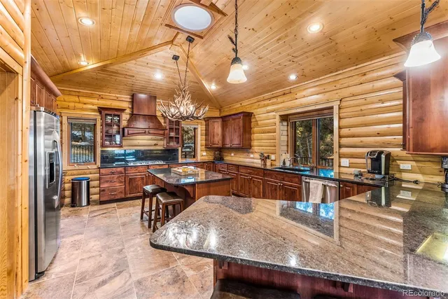a kitchen with stainless steel appliances granite countertop a sink a counter space and cabinets