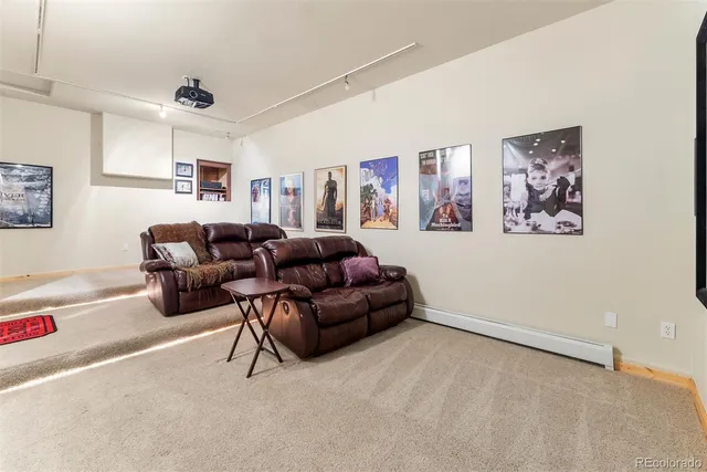 a living room with furniture a couch and paintings on the wall