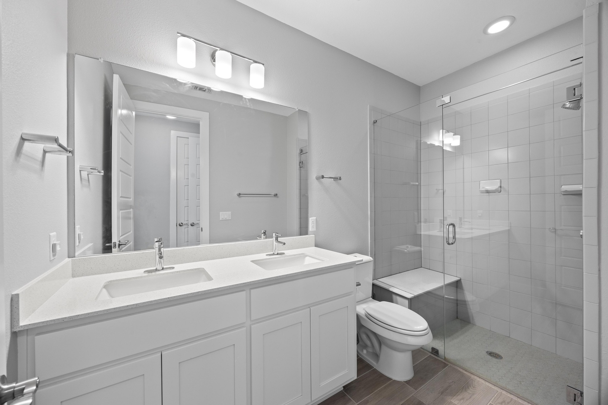 2222 Simond Avenue, Unit E Austin, TX 78723 - Photo 16 of 28 The primary bathroom has a dual sink vanity and walk-in shower.