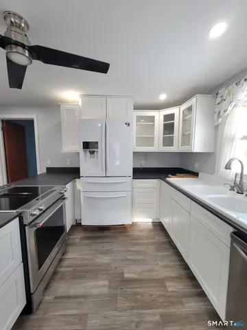 a large kitchen with granite countertop a stove and a sink