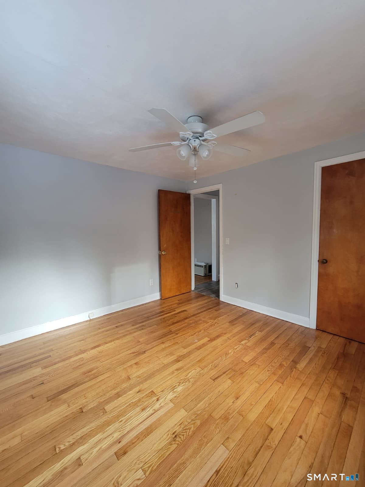 895 Pleasant Valley Road South Windsor, CT 06074 - Photo 8 of 15 a view of an empty room with wooden floor and a ceiling fan