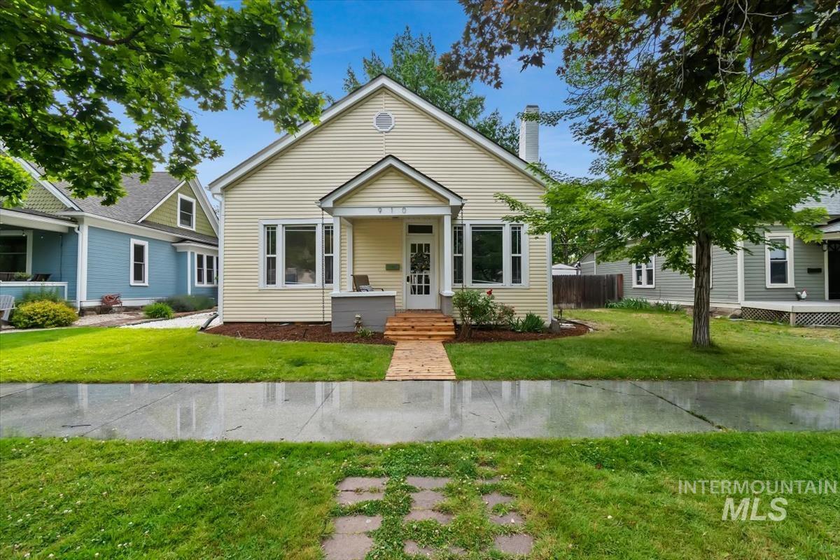 Cream siding exterior with a welcoming front porch featuring wood-finish steps