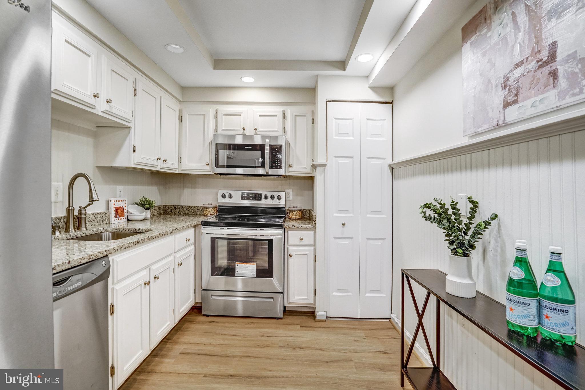 7640 Provincial Drive, Unit 109 McLean, VA 22102 - Photo 18 of 47 a kitchen with stainless steel appliances white cabinets a sink a stove a refrigerator and a potted plant