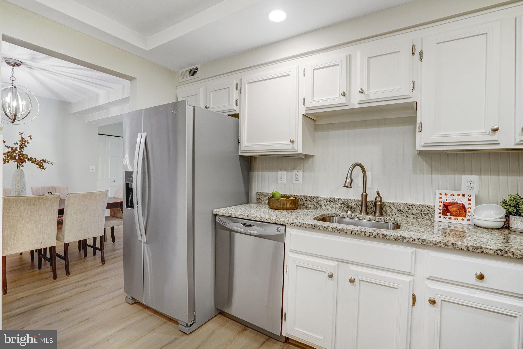 7640 Provincial Drive, Unit 109 McLean, VA 22102 - Photo 20 of 47 a kitchen with stainless steel appliances granite countertop a refrigerator sink and cabinets