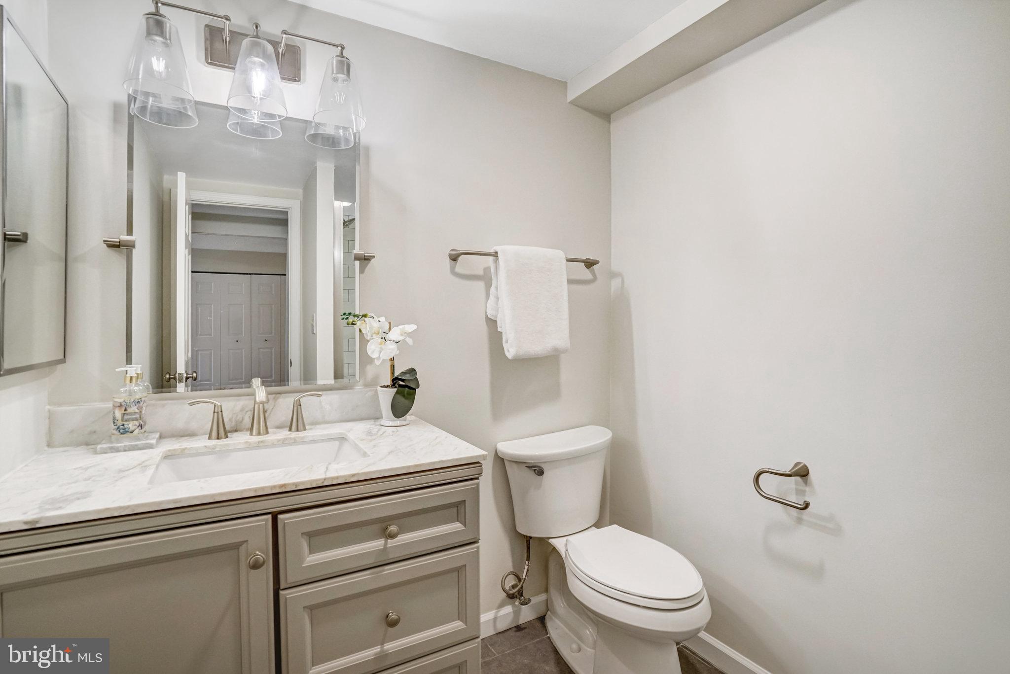 7640 Provincial Drive, Unit 109 McLean, VA 22102 - Photo 34 of 47 a bathroom with a granite countertop toilet a sink and a mirror