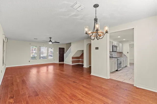 a view of a room with wooden floor windows and a chandelier