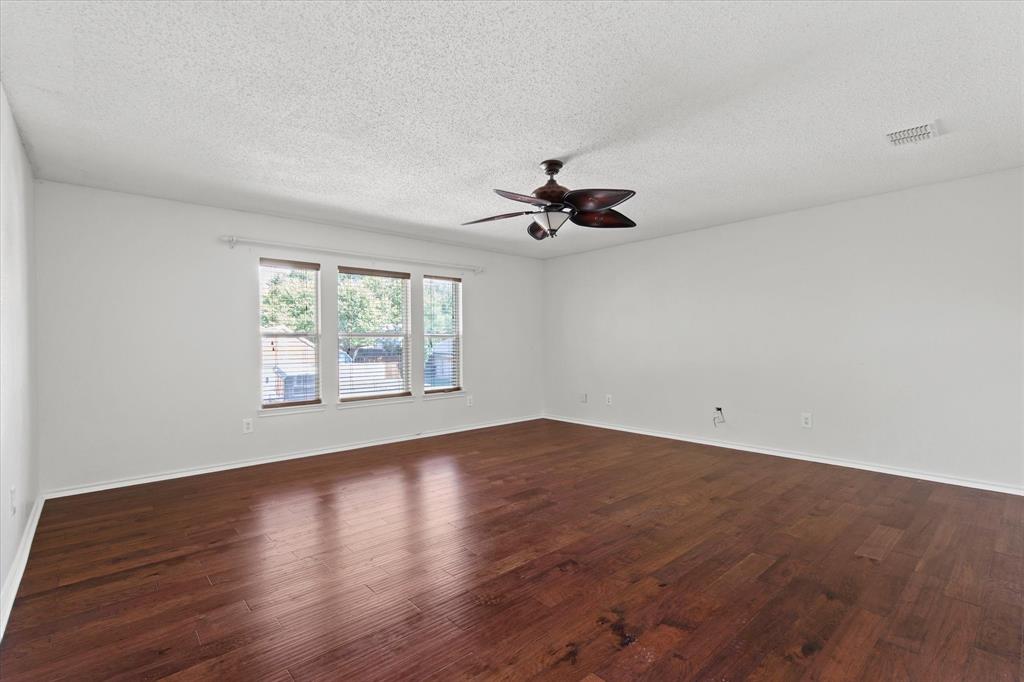 2201 Driskell Lane Corinth, TX 76210 - Photo 21 of 40 an empty room with wooden floor fan and windows