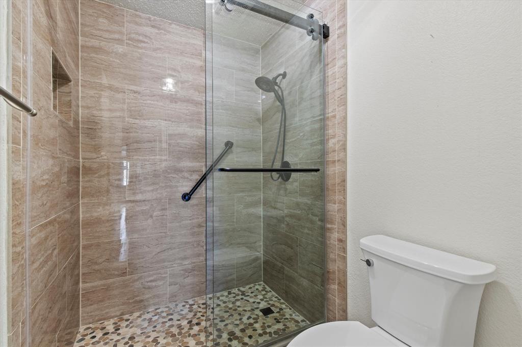 2201 Driskell Lane Corinth, TX 76210 - Photo 25 of 40 a bathroom with a shower and toilet
