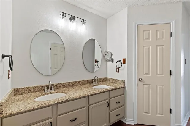 a bathroom with a granite countertop double vanity sinks and a mirror