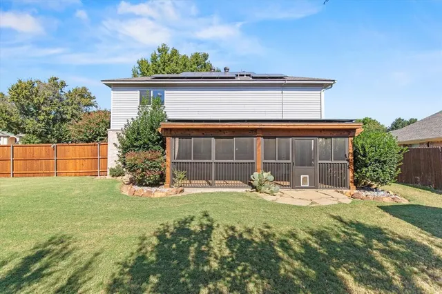 a view of a yard in front of a house with a large tree