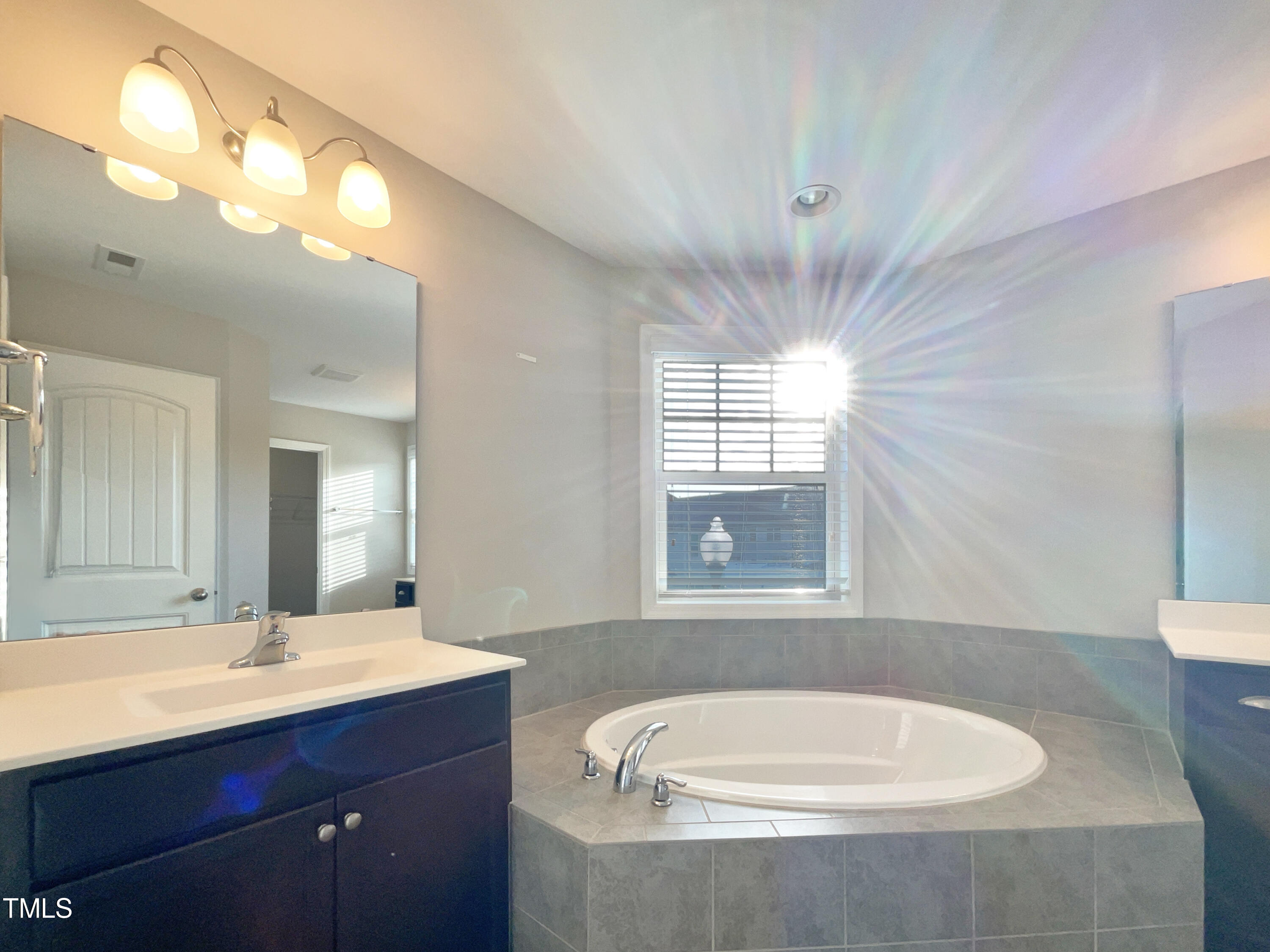 7828 Weathered Oak Way Raleigh, NC 27616 - Photo 22 of 22 a bathroom with a bathtub a sink and a mirror
