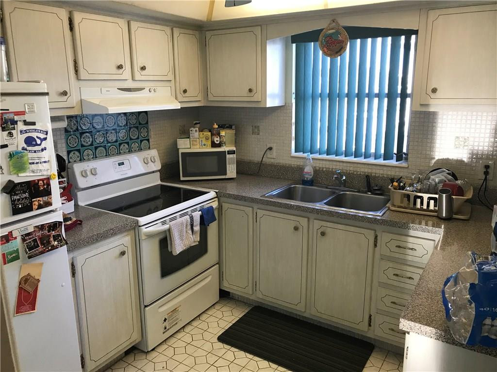 1150 East Sample Road, Unit 201 Pompano Beach, FL 33064 - Photo 5 of 8 a kitchen with granite countertop a sink a stove and cabinets