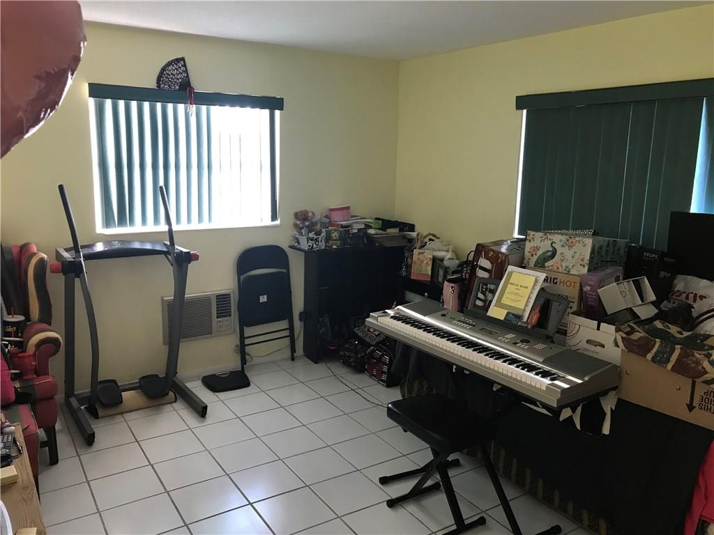 1150 East Sample Road, Unit 201 Pompano Beach, FL 33064 - Photo 6 of 8 a bedroom with furniture and a window