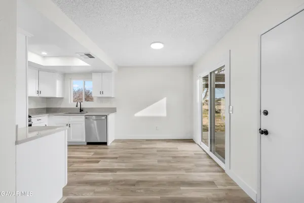 a view of a kitchen with wooden floor and electronic appliances