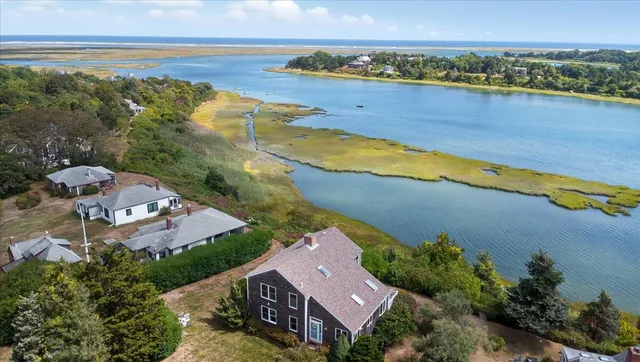 an aerial view of a house with a garden and lake view