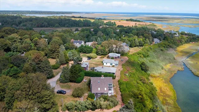 an aerial view of ocean and residential houses with outdoor space