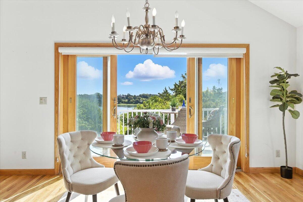 60 Smith Heights Way Eastham, MA 02642 - Photo 45 of 70 a dining room with furniture a chandelier and wooden floor