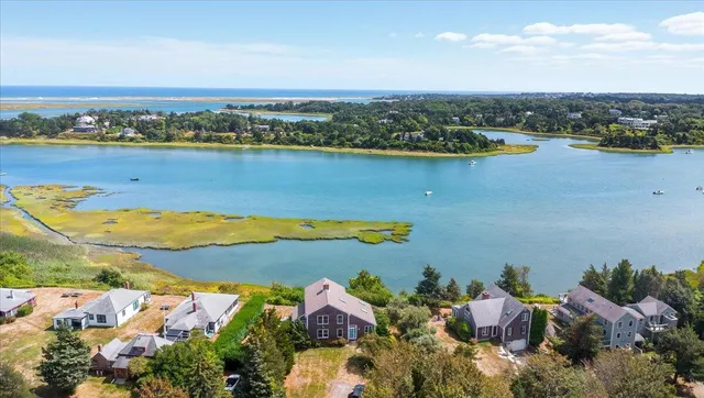 an aerial view of a house with a yard and lake view