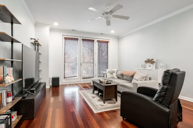 a living room with furniture a large window and wooden floor
