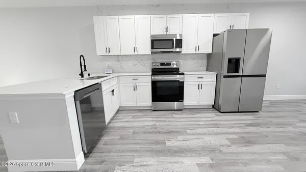 a kitchen with stainless steel appliances a refrigerator stove microwave and sink