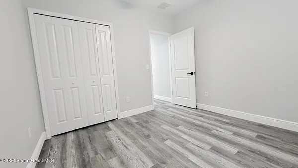 a view of an empty room with wooden floor