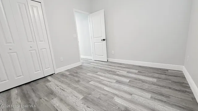 a view of an empty room with wooden floor