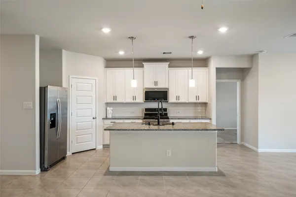 a kitchen with stainless steel appliances granite countertop a refrigerator sink and cabinets