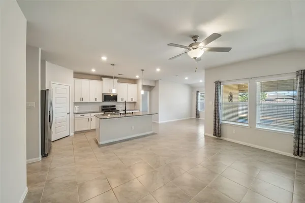 a large kitchen with stainless steel appliances kitchen island granite countertop a refrigerator and a stove top oven