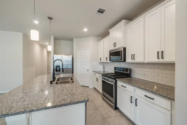 a kitchen with stainless steel appliances granite countertop a sink a stove oven and granite counter tops