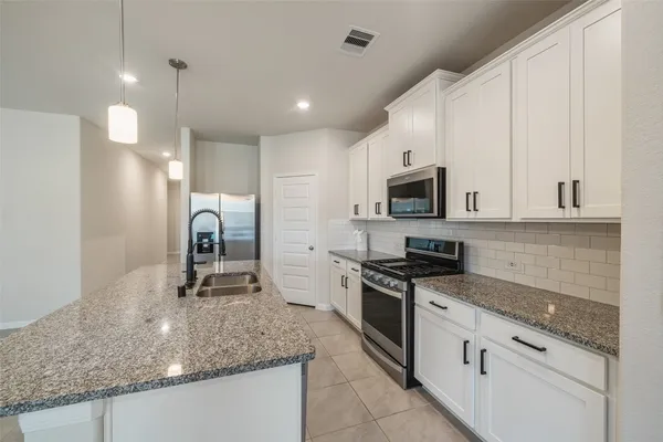 a kitchen with stainless steel appliances granite countertop a sink a stove oven and granite counter tops