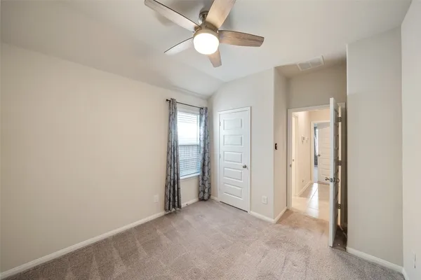 an empty room with closet and a ceiling fan