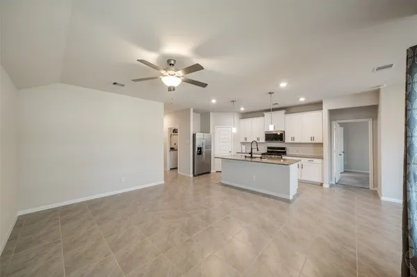 a view of kitchen with kitchen island stainless steel appliances refrigerator stove a sink dishwasher with a dining table and chairs