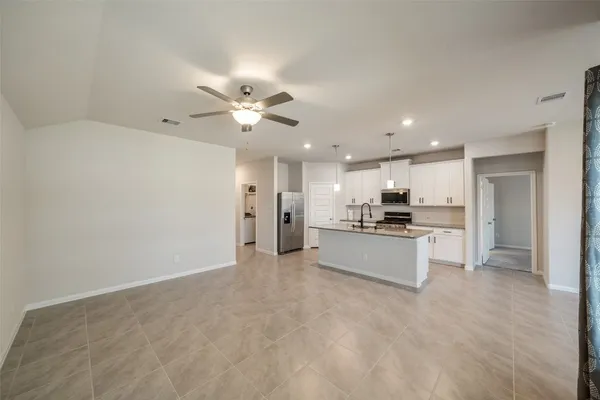 a view of kitchen with kitchen island stainless steel appliances refrigerator stove a sink dishwasher with a dining table and chairs