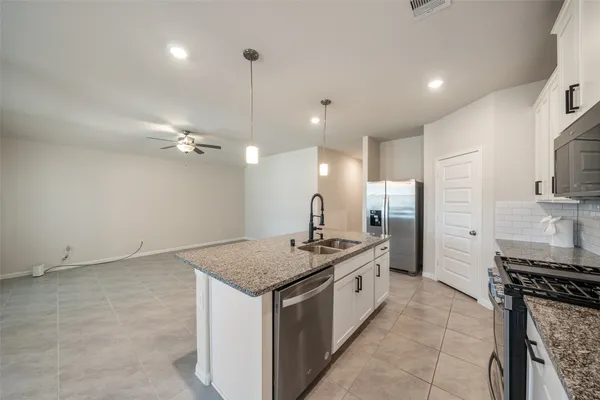 a kitchen with a stove a sink a refrigerator and a counter top space