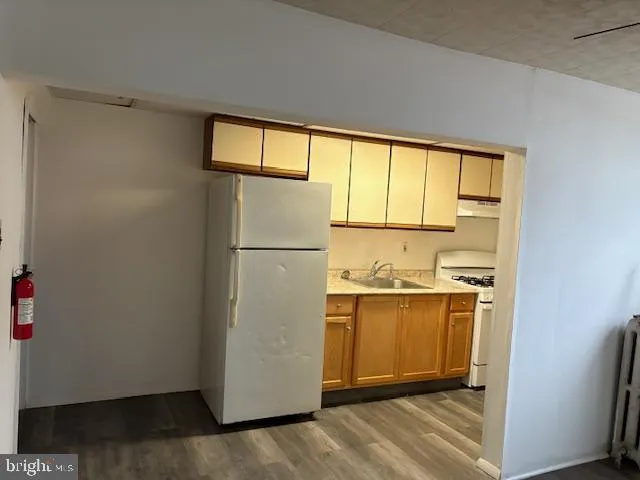 a kitchen with a refrigerator a stove and a window