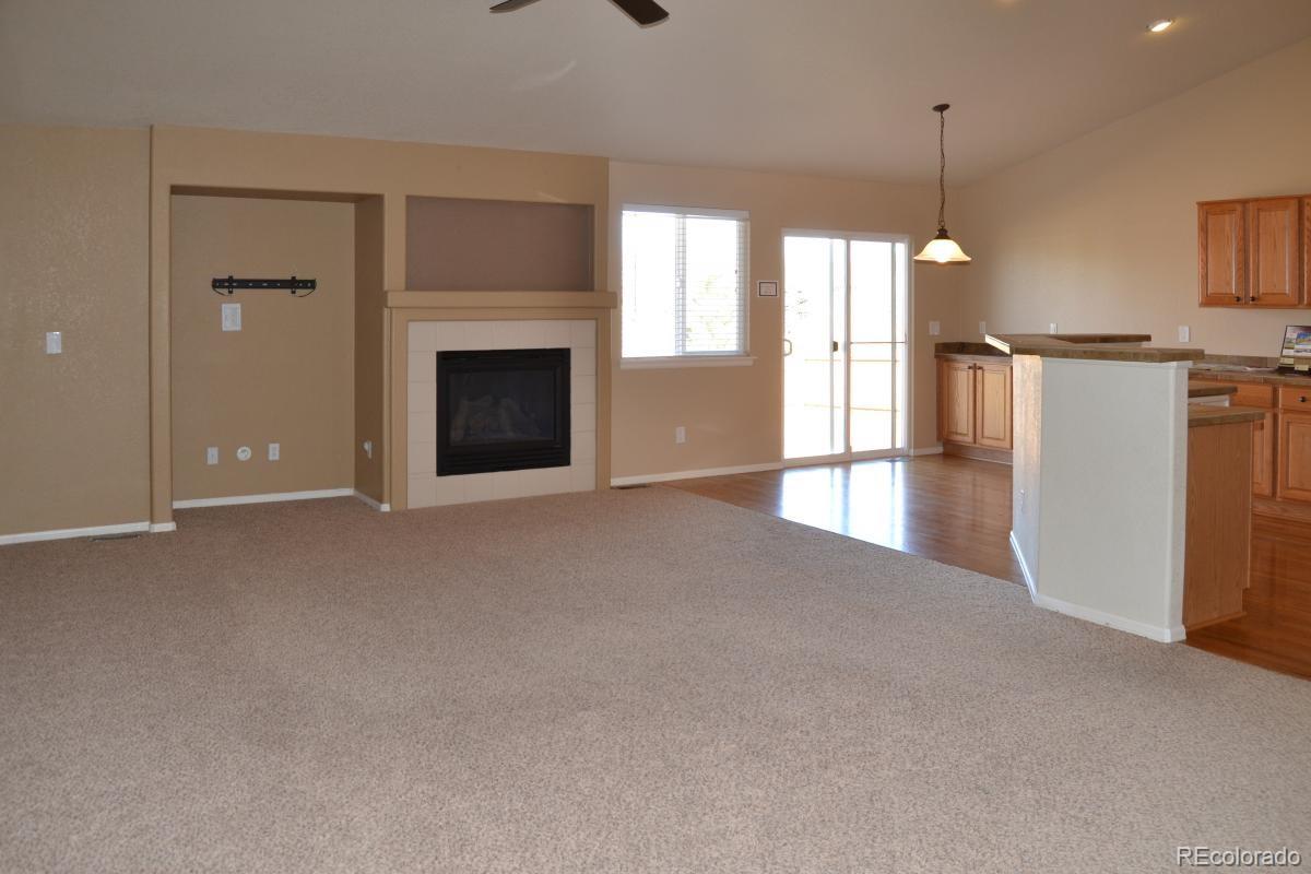 8039 Raspberry Drive Frederick, CO 80504 - Photo 8 of 28 a view of an empty room with a fireplace and a window