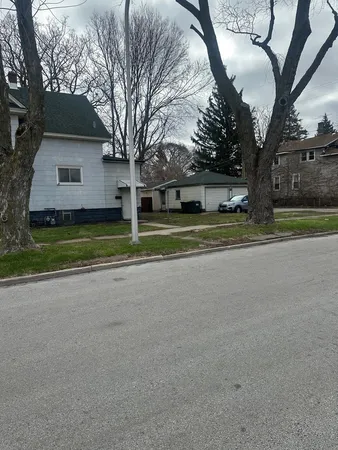 a view of a house with a big yard and large trees