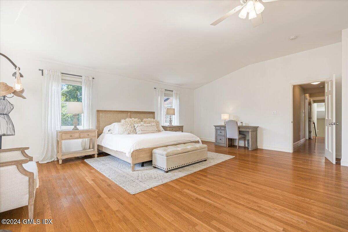 70 Gregory Road Cos Cob, CT 06807 - Photo 13 of 39 a spacious bedroom with a bed a dresser and a chandelier
