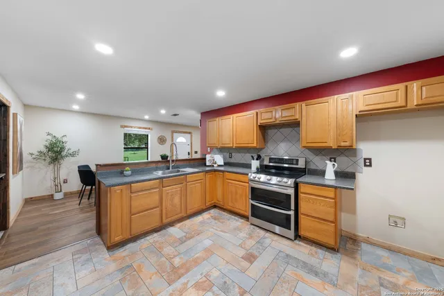 a kitchen with stainless steel appliances granite countertop a stove a sink and a refrigerator