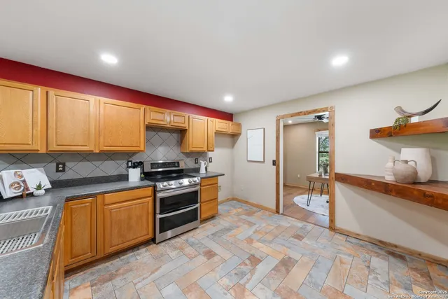 a kitchen with stainless steel appliances granite countertop a stove a sink and a refrigerator
